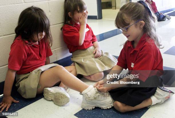 Electra Cooley, right, ties the shoe of a new Kindergarten classmate at Bellaire Elementary school in Bossier City, Louisiana on Wednesday September...