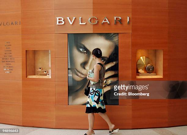 Woman looks at a jewelry display as she walks past a Bulgari store in Shanghai Monday, August 8, 2005. China's growing demand for gold necklaces,...