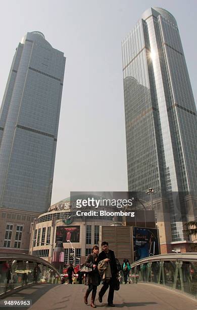 Couple walks in front of Grand Gateway Mall, developed by Hang Lung Properties Ltd., in Shanghai, China, on Wednesday, Feb. 20, 2008. Hang Lung...