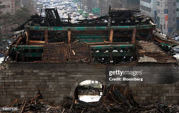 Investigators look at the remains of Sungnyemun Gate, also called Namdaemun, or South Gate, in Seoul, South Korea, on Monday, Feb. 11, 2008. Fire...