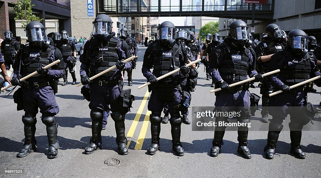 Police officers in riot gear monitor a rally from the State