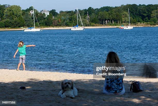 Jill Mueller watches her daughter Emily throw stones into Sag Harbor Bay in Sag Harbor, New York, U.S., on Sunday, Aug. 31, 2008. The business...