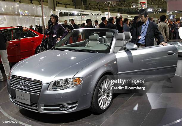 Visitor steps into an Audi A4 cabriolet at the Tokyo Motor Show Wednesday, October 19, 2005.