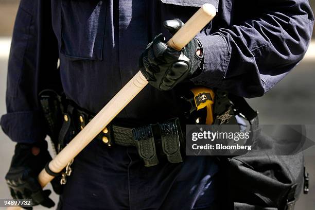 Police officer holds a nightstick while monitoring a Veterans for Peace rally from the State Capitol to the Xcel Center, site of the Republican...