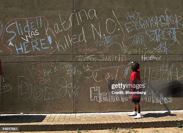 Boy adds his contribution to a wall full of chalk graffiti on the exterior of a Louisiana State University gymnasium in Shreveport, Louisiana,...