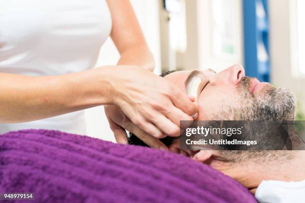 man krijgt wenkbrauwen gewaxt - beauty spa stockfoto's en -beelden