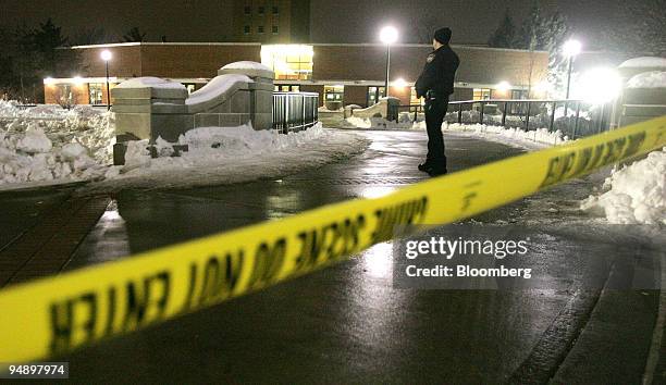 Police officer stands guard at his post beyond crime-scene tape outside Cole Hall on the campus of Northern Illinois University in DeKalb, Illinois,...