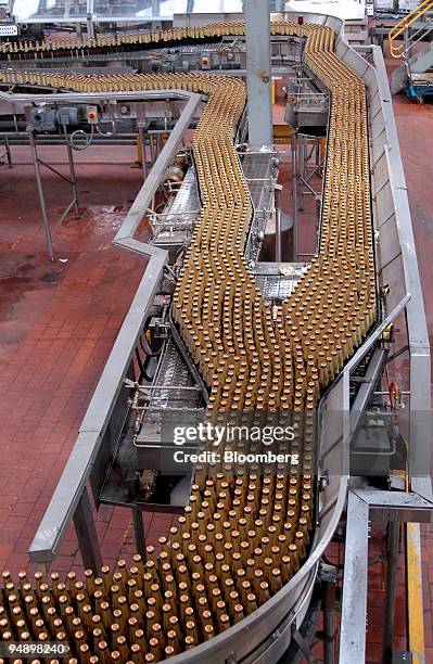 Bottles of Crown lager beer move along a conveyor belt for packaging at a Foster's Group Ltd. Brewery in Melbourne, Australia, on Monday, Feb. 18,...