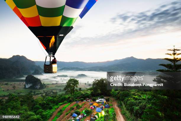colorful hot air balloons flying over mountain national park with sunrise and morning mist at phayao provincethailand. - hot air balloon ride stock-fotos und bilder