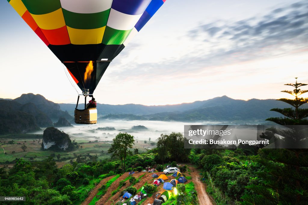 Colorful hot air balloons flying over mountain national park with sunrise and morning mist at Phayao provinceThailand.