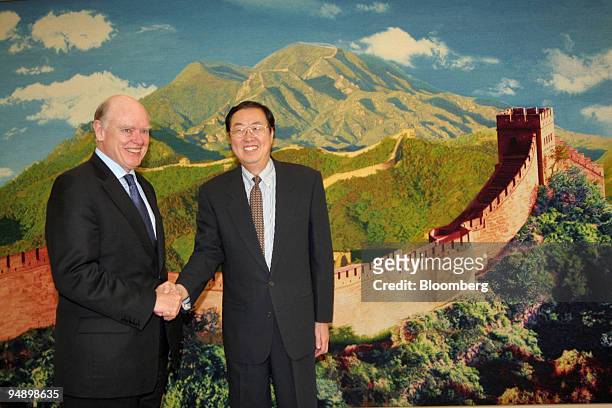 Visiting U.S. Treasury Secretary John Snow, left, shakes hands with Zhou Xiaochuan, the governor of the People's Bank of China, shortly before their...