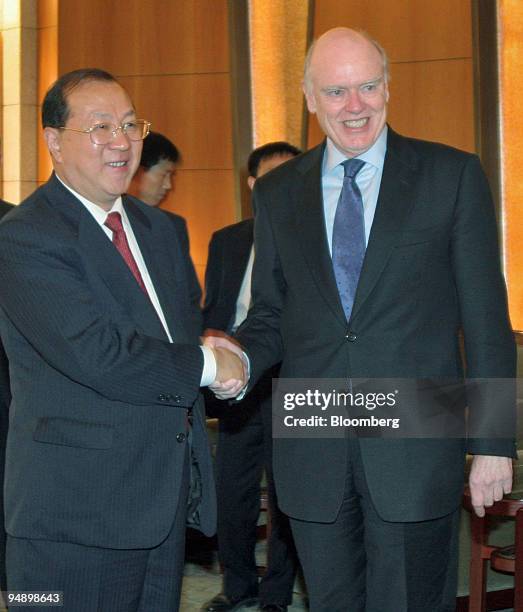 Visiting U.S. Treasury Secretary John Snow, right, shakes hands with Chinese Finance MInister Jin Renqing, before the start of their meeting Monday,...