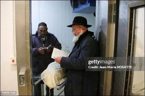 Deux membres de la Hevra Qadisha, les pompes funebres religieuses de Jerusalem recietnt des psaumes pres de la depouille de Ilan Halimi.