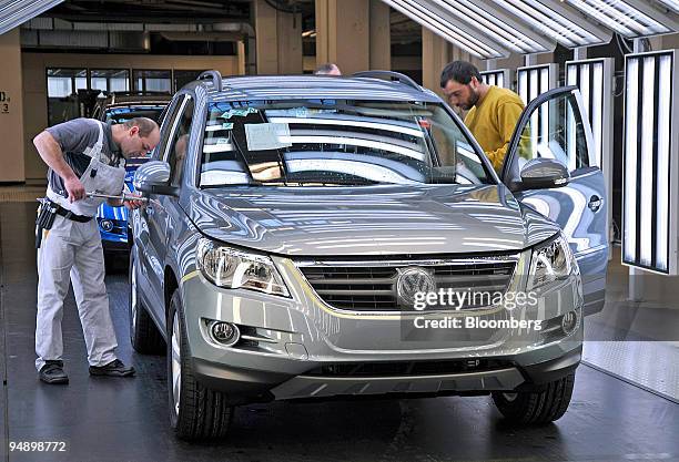 Workers check a Volkswagen Tiguan car on an automobile on the production line at the Volkswagen factory in Wolfsburg, Germany, on Friday, Feb. 15,...