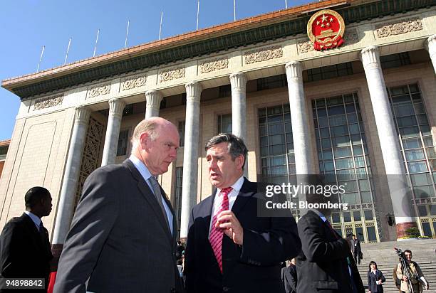 Treasury Secretary John Snow, left, speaks with British Chancellor of the Exchequer Gordon Brown, right, on the steps of the Great Hall of the People...