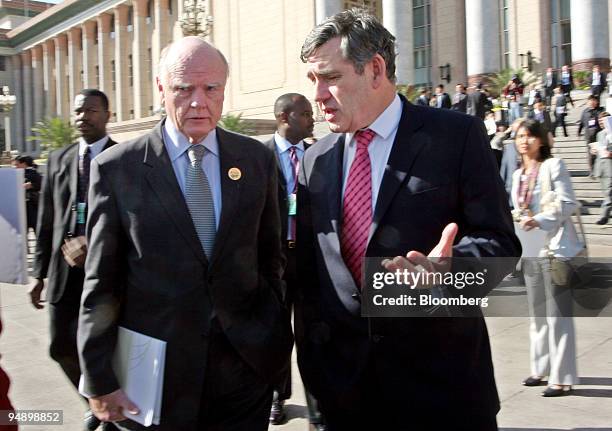 Treasury Secretary John Snow, left, speaks with British Chancellor of the Exchequer Gordon Brown, right, outside the Great Hall of the People...