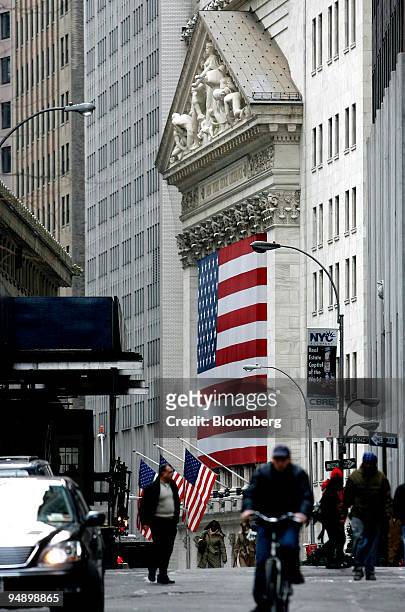 Pedestrians and a bike rider pass by the New York Stock Exchange in New York, U.S., on Friday, Feb. 15, 2008. Most U.S. Stocks dropped for a second...