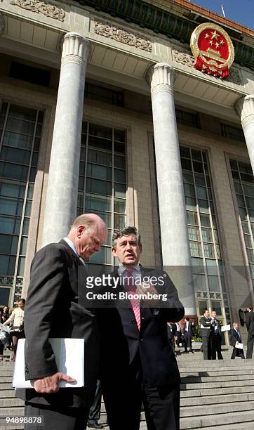 Treasury Secretary John Snow, left, speaks with British Chancellor of the Exchequer Gordon Brown, right, outside the Great Hall of the People...