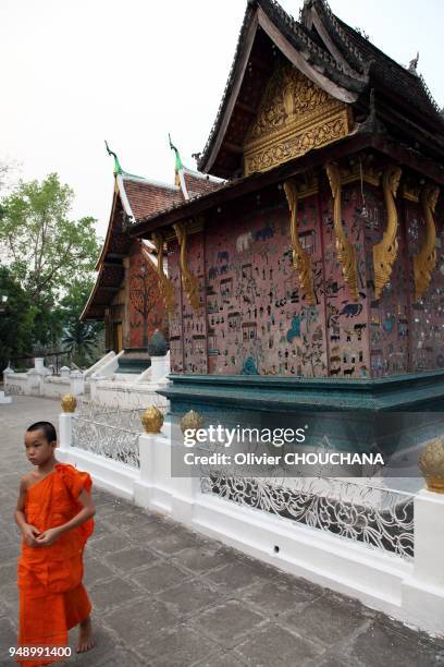Young monk passes by near Wat Xieng Thong temple on April 08, 2012 in Luang Prabang, Laos.