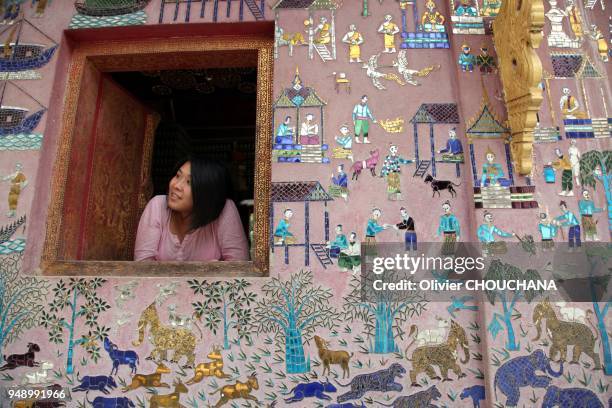 Tourist looks out from Wat Xieng Thong also known as the Golden city temple on April 08, 2012 in Luang Prabang, Laos.