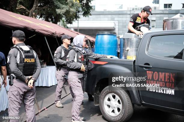 Indonesian police unload the stock of recently seized bootleg liquor prior to a press conference in Jakarta. - Police have arrested the main suspect...