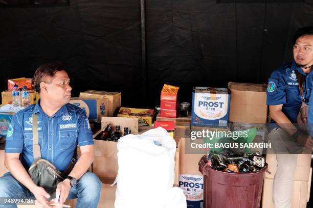 Indonesian police guard the stock of recently seized bootleg liquor prior to a press conference in Jakarta. - Police have arrested the main suspect...