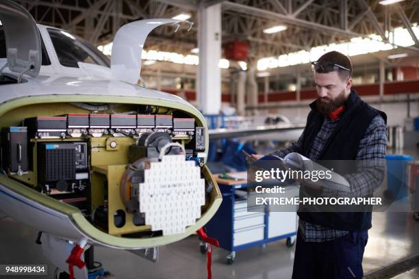 meccanico aeronautico nell'hangar - manuale foto e immagini stock
