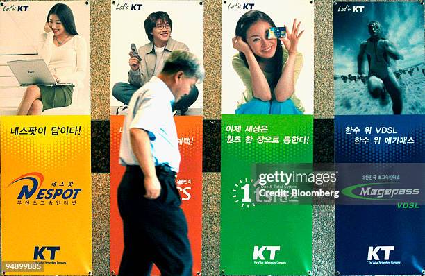 Customer walks past banners advertising KT Corp.'s services at a branch office in Ilsan, South Korea Friday, August 6, 2004. South Korea's largest...
