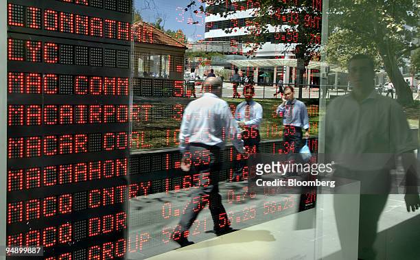 Pedestrians are reflected in the glass over an Australian Securities Exchange board in Sydney, Australia, on Thursday, Feb. 14, 2008. ASX Ltd.,...