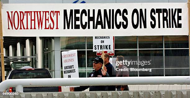 Year veteran Northwest Airlines mechanic Steve McNeese waves to cars as he pickets outside the Ted Stevens Anchorage International Airport in...