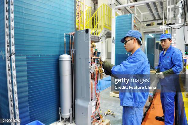 Workers assemble air conditioners in a sino-Japan joint venture between Mitsubishi Heavy Industries and Haier in Qingdao in east China's Shandong...