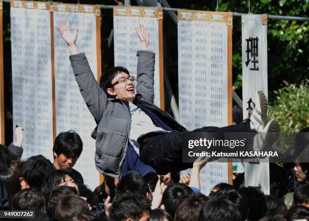 Student who passes an entrance examination of Tokyo University, is tossed in the air to congratuate at school campus, Thursday. Total 3009 students...