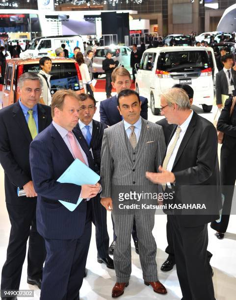 Carlos Ghosn, president and CEO of Nissa, second from right, inspects a hall after his presentation during a press preview day of the Tokyo Motor...