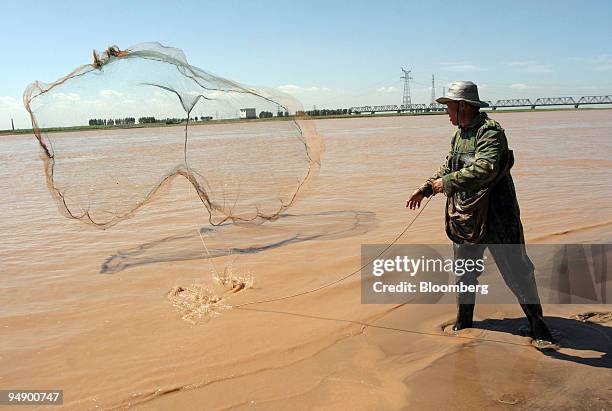 Chinese fisherman casts a net into the Yellow River near Baotou, Inner Mongolia, China Thursday, August 18, 2005.