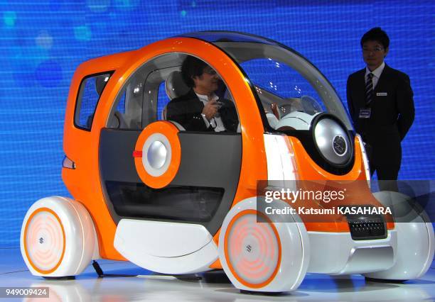 Visiter checks in a seat if Suzuki's two-seat micro-vihicle " Q-concept" during a press preview day of the Tokyo Motor Show 2011 in Tokyo, Nov. 30,...