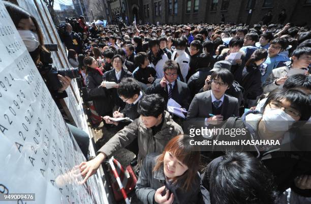 Entrance examinees and relatives check examinees' number at the board in Tokyo University campus, Thursday. Total 3009 students are enrolled today.