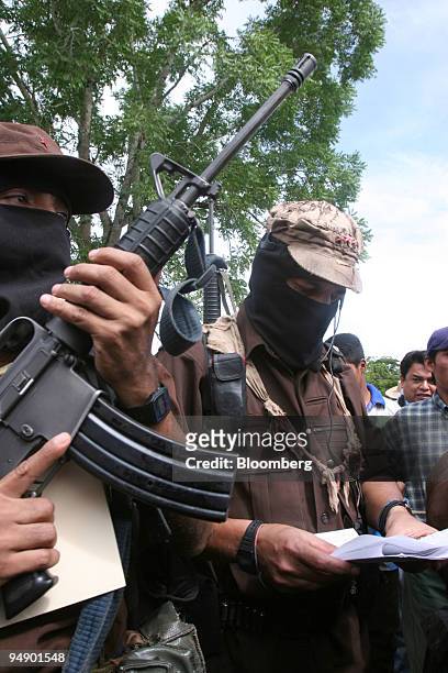 Subcomandante Marcos of the National Liberation Army , right, refers to his notes during a meeting with members of the Dolores Hidalgo commune in the...