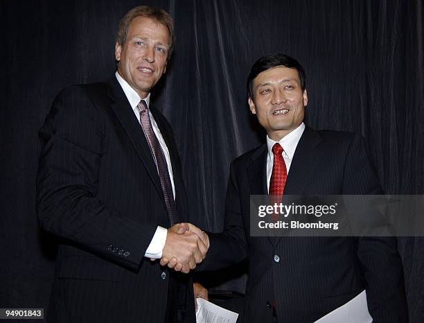 Alan Cransberg, managing director of Alcoa Australia, left, and Xiao Yaqing, president of Aluminum Corp. Of China Ltd. , shake hands following a news...