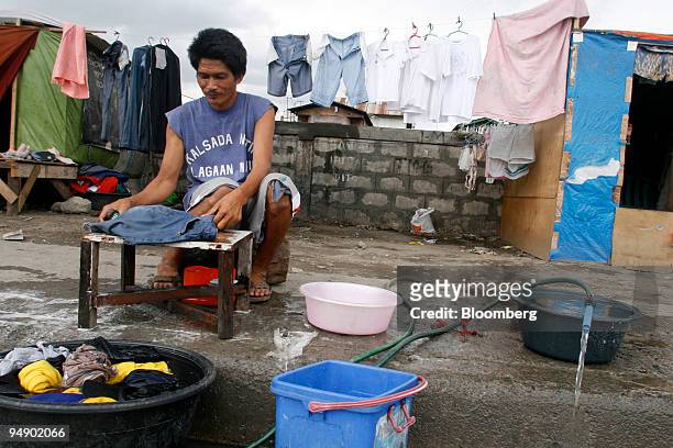 Squatter washes clothes from an illegal water tap on a sidewalk in Manila, the Philippines, on Saturday, Feb. 2, 2008. Philippine inflation probably...