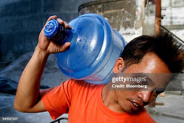 Delivery worker carries a bottle of purified water in Manila, the Philippines, on Friday, Feb. 1, 2008. Philippine inflation probably accelerated in...