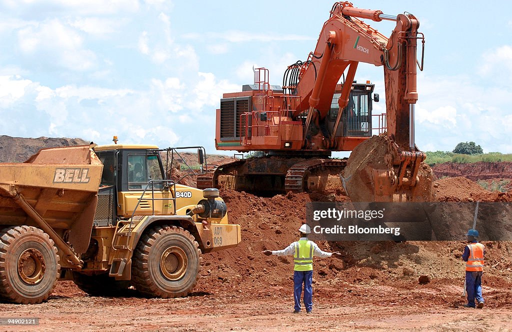 A mine worker gestures while directing a truck at a quarry a