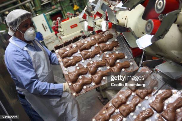 An employee removes chocolate bunny molds from a machine at the kosher certified Madelaine Chocolate Novelties, Inc. Factory in the Queens borough of...
