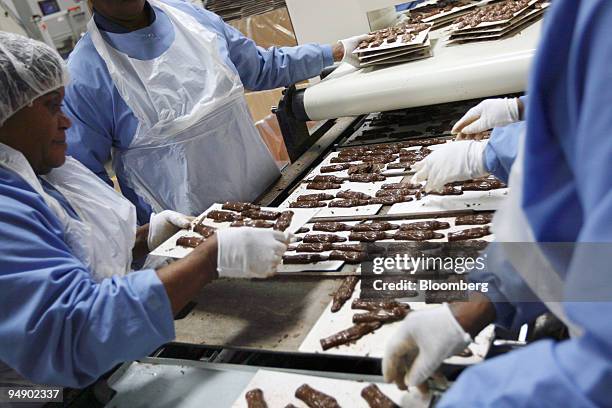 Employees pull cooled chocolate bunnies out of a conveyer at the kosher certified Madelaine Chocolate Novelties, Inc. Factory in the Queens borough...