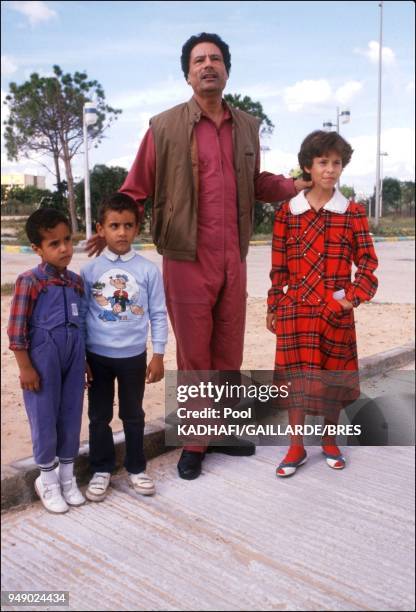 Colonel Muammar Gaddafi, with daughter Aicha and sons, near Bab Azizia palace, destroyed in a US air raid and left in ruins, in November 1986, in...