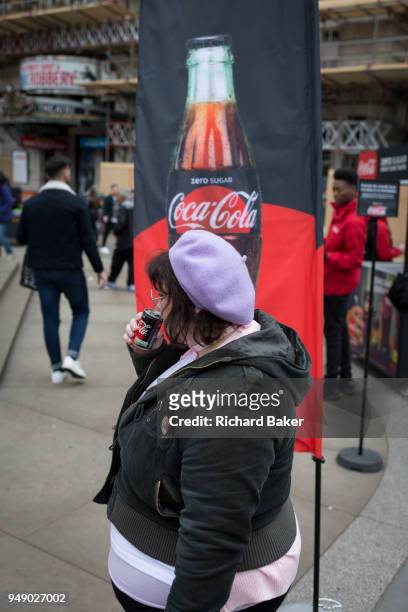 Passer-by tastes a sample of the new Zero Sugar Coca-Cola drinks, given out in Piccadilly Circus, on 16th April 2018, in London, England.