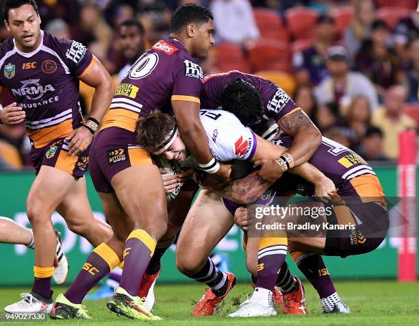 Christian Welch of the Storm is wrapped up by the defence during the round seven NRL match between the Brisbane Broncos and the Melbourne Storm at...