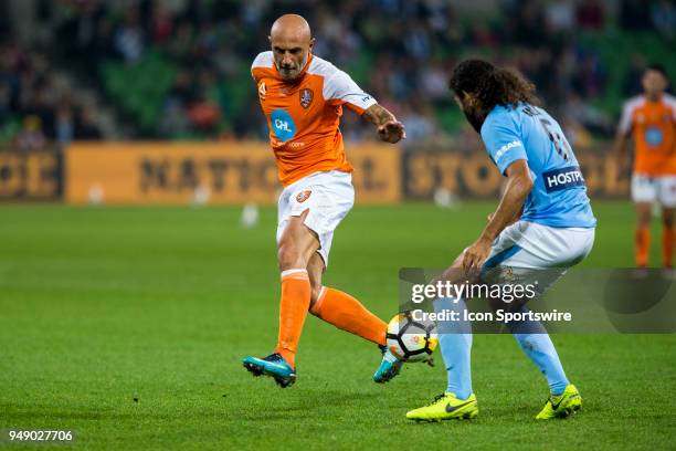 Massimo Maccarone of the Brisbane Roar kicks the ball with his back leg in front of Osama Malik of Melbourne City during the Elimination Final of the...