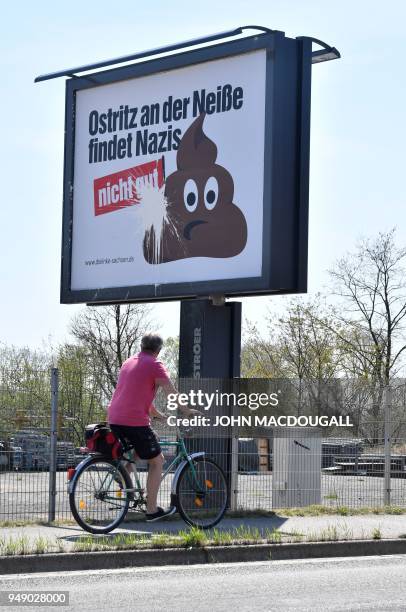 Man cycles past a billboard standing at the outskirts of Goerlitz, eastern Germany, on the road to Ostritz, that reads "Ostritz on the Neisse finds...