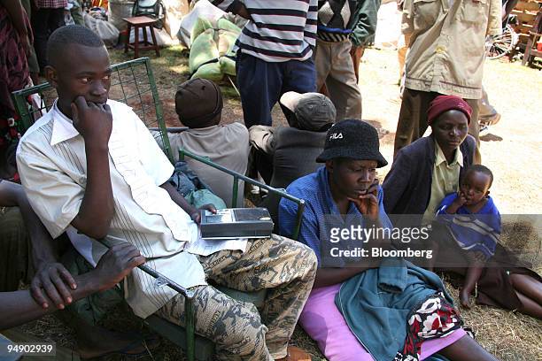 Displaced families listen to news on the radio as they shelter at Tigoni police station near Nairobi, Kenya, on Thursday, Jan. 31, 2008. Kenyan peace...