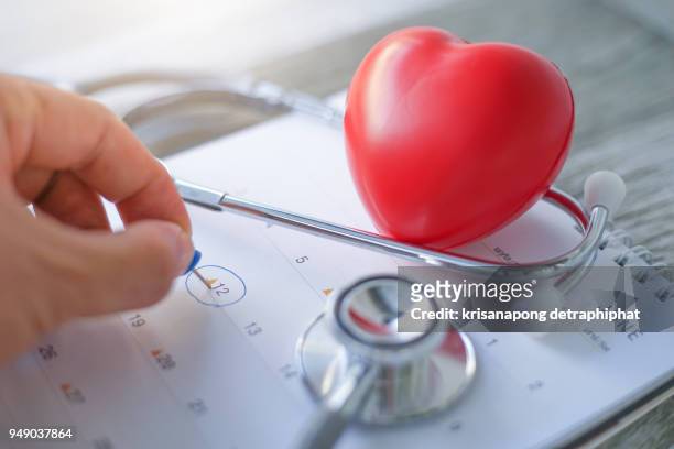 doctor appointment on a calendar with a blue push pin to remind you and important appointment. - medicaid stock pictures, royalty-free photos & images